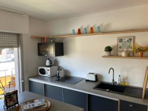 a kitchen with a sink and a microwave at La pointe Cap ferret in Lège-Cap-Ferret