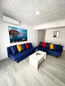 Una sala de estar con dos sofás azules y una mesa. en Centro Apartamentos, en Alicante