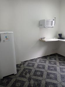 a kitchen with a refrigerator and a microwave at Kitnet Penha CEFAN ADVEC in Rio de Janeiro