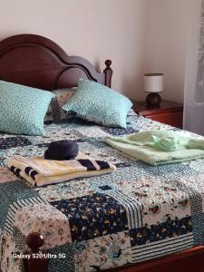 a bed with a blanket and pillows on it at AL Luso Brasileiro in Lajes das Flores