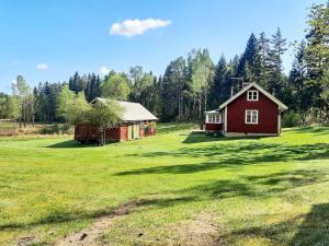 ein rotes Haus und eine Scheune auf einem Feld in der Unterkunft Holiday home Fjärås II in Fjärås