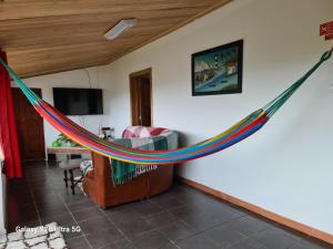 a hammock is hanging in a living room at AL Luso Brasileiro in Lajes das Flores