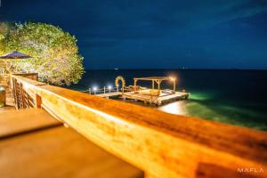 a wooden dock in the water at night at Rosario EcoHotel in Isla Grande