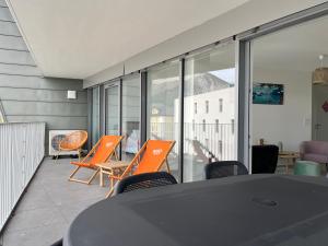 une salle à manger avec des chaises orange et une table dans l'établissement ENTRE NOUS CITY, à Annecy