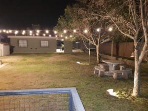 un patio trasero por la noche con una mesa de picnic y luces en Residencial Las Lechuzas en 
