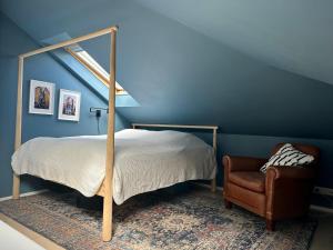 1 dormitorio con 1 cama y 1 silla en Bright and Spacious 4 bedroom apartment in Hlíðar, Reykjavik en Reikiavik