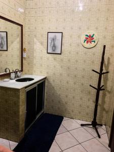 a bathroom with a sink and a mirror at Guest House do Magoo in Arraial do Cabo