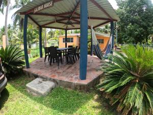 un patio con mesa, sillas y hamaca en SALIMAR - Barra de Santiago, en Barra de Santiago