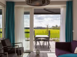 a living room with a table and chairs and a window at Premier Holiday Home in Oostkapelle With Sauna in Oostkapelle