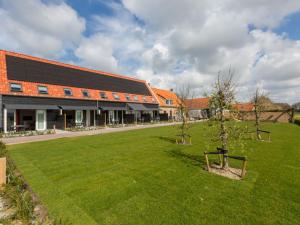 a large building with a green lawn in front of it at Premier Holiday Home in Oostkapelle With Sauna in Oostkapelle