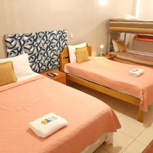 a hotel room with two beds in a room at 102 RV APARTMENTS IQUITOS-APARTAMENTO FAMILIAR CON PISCINA in Iquitos