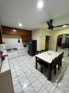 eine Küche und ein Esszimmer mit einem Tisch und Stühlen in der Unterkunft JL Homestay Taman Pertama Satu in Lahad Datu