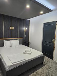 um quarto com uma cama e uma porta preta em Vila Massimo em Eforie Nord