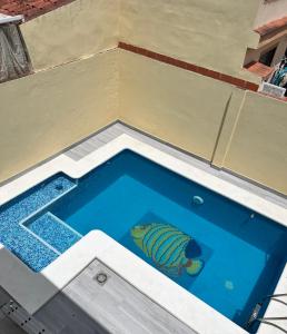 um peixe está sentado numa piscina em Ribera house Sevilla em Coria del Río