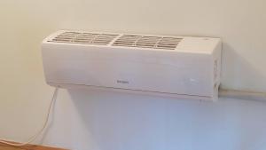 a white air conditioner sitting on top of a refrigerator at Janković Apartmani u centru in Soko Banja +49 photos