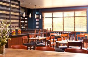 a restaurant with tables and chairs and a bar at Four Points by Sheraton Memphis Southwind in Memphis
