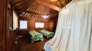 a room with two beds in a wooden house at TAHITI - Fare Te Pari in Mariuti