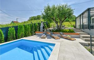 a swimming pool with two lounge chairs and a house at 3 Bedroom Beautiful Home In Beretinec in Beretinec