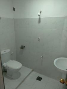 Baño blanco con aseo y lavamanos en UPPUVELI BEACH HOUSE, en Trincomalee
