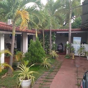 een huis met palmbomen ervoor bij UPPUVELI BEACH HOUSE in Trincomalee