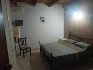una camera con un letto e una sedia di Villa Marano a Caianello Vecchio