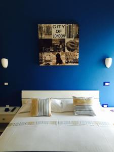 a bedroom with a blue wall with a large bed at B&B Zahir in Castro di Lecce