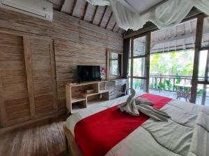 sypialnia z dużym łóżkiem i telewizorem w obiekcie Sri Permana Suite and Villa Ubud w mieście Ubud