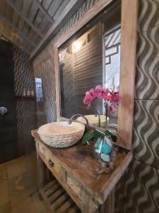 łazienka z umywalką z lustrem i kwiatami w obiekcie Sri Permana Suite and Villa Ubud w mieście Ubud