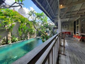a pool in the middle of a house with a wooden deck at Sri Permana Suite and Villa Ubud in Ubud