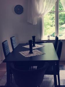 a dining room table with chairs and a clock on the wall at GolfHuset 