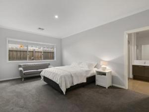 - une chambre avec un lit, une chaise et une fenêtre dans l'établissement Breeze on Inn Surfside, à Inverloch