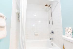 a white bathroom with a tub and a shower at The Frontier Flat in Key West