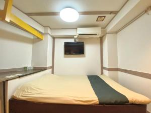 a small room with a bed and a tv at Tabist Hotel Florida Ikebukuro in Tokyo