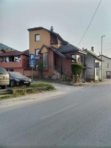 a street with houses and a parking lot with a car at Sobe Centar in Visoko