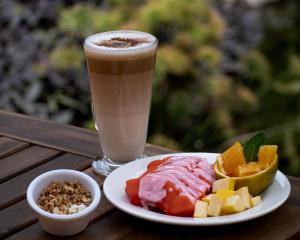 a plate of food and a drink on a wooden table at Hotel Villa Pralaya in Jiutepec