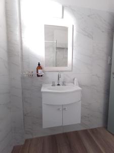 Baño blanco con lavabo y espejo en Paraná Estudio en Buenos Aires