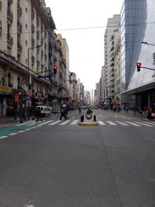 una concurrida calle de la ciudad con gente cruzando la calle en Paraná Estudio en Buenos Aires