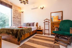 a bedroom with a bed and a green chair at COUNTRYSIDE VILLA in Ulcinj