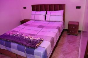 - une chambre violette avec un grand lit et des draps violets dans l'établissement la perle rare de Sidi Ifni, à Sidi Ifni