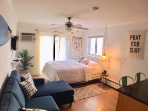 een slaapkamer met een bed en een blauwe bank bij Jonathan's Ocean Front Studio Suites Hampton Beach! in Hampton
