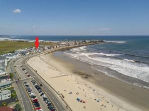 een luchtzicht op een strand met auto's en mensen bij Jonathan's Ocean Front Studio Suites Hampton Beach! in Hampton