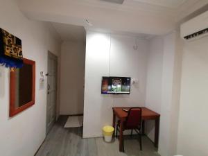 um quarto com uma mesa e uma televisão na parede em Mi Hotel 2 Dungun em Dungun