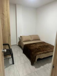 1 dormitorio con 1 cama y 1 silla en una habitación en Lindo apartamento Medellín zona céntrica, en Medellín