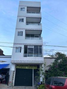 a tall white building with a garage in front of it at Lindo apartamento Medellín zona céntrica in Medellín