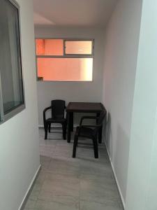 a room with a table and two chairs and a window at Lindo apartamento Medellín zona céntrica in Medellín