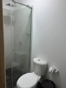 a bathroom with a toilet and a glass shower at Lindo apartamento Medellín zona céntrica in Medellín
