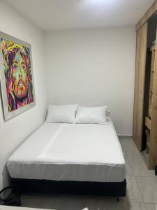 1 cama en una habitación con un cuadro en la pared en Lindo apartamento Medellín zona céntrica, en Medellín