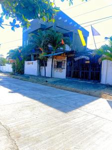 ein blaues Gebäude mit Palmen davor in der Unterkunft Playa de Bombora Inn in Cabugao