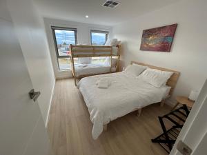 a small bedroom with two bunk beds and a table at Powder Peaks in Jindabyne