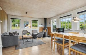 - une salle à manger et un salon avec une table et des chaises dans l'établissement Cozy Home In Tranekr With Kitchen, à Tranekær
